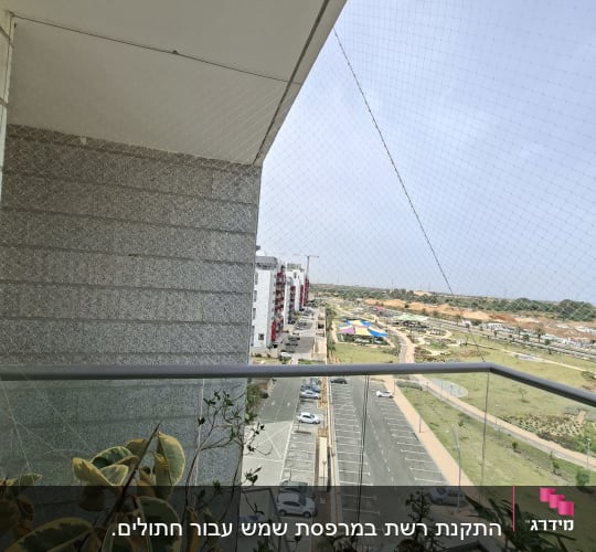 רשת יונים מותקנת במרפסת עם עציצים